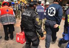 An emergency responder in Mexico City carries an orange case holding a radar instrument called FINDER.